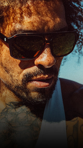 Close-up of a person wearing sunglasses with a blurred background