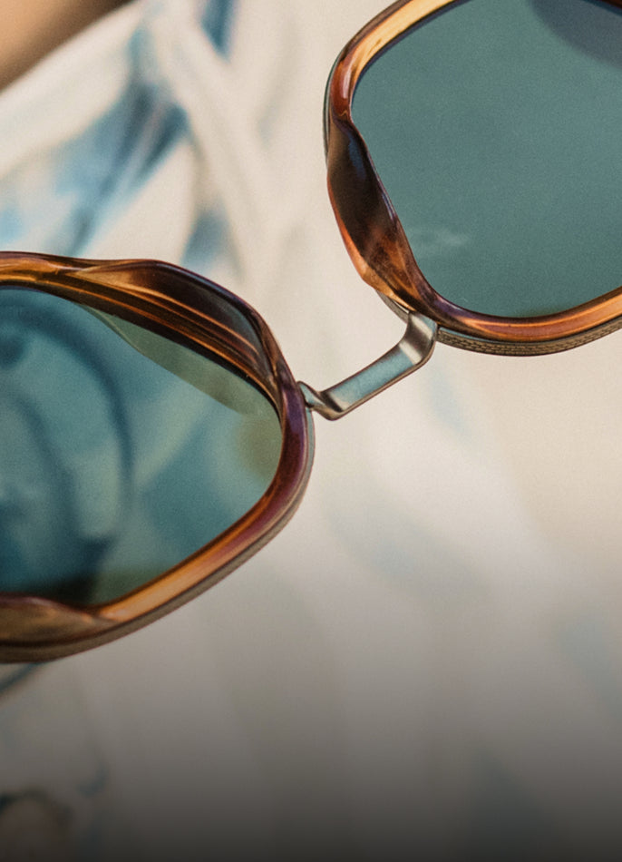 Close-up of sunglasses with reflective lenses on a blurred background