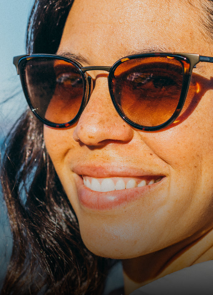Close-up of a person wearing sunglasses with a blurred background