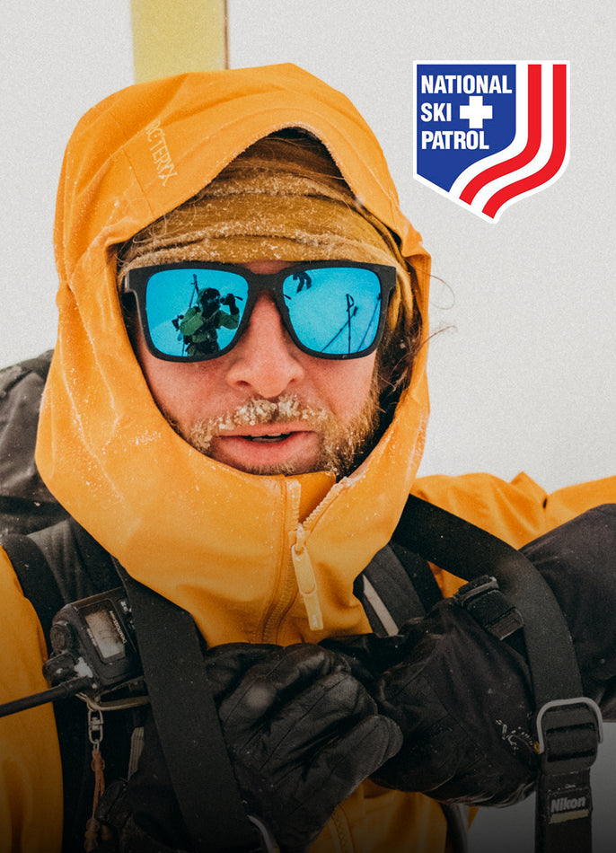 Person wearing a yellow ski patrol jacket with a National Ski Patrol logo in the corner.