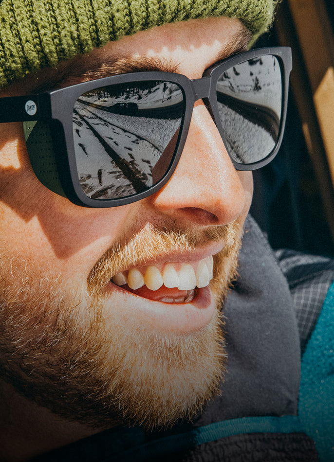 Close-up of a person wearing sunglasses with a blurred background