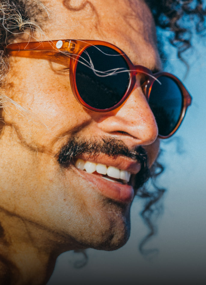 Close-up of a person wearing sunglasses with a blurred background