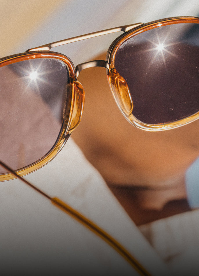 Sunglasses with reflective lenses on a blurred background