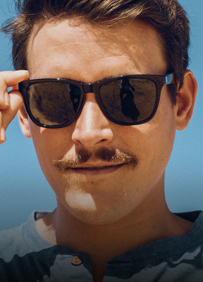Man wearing sunglasses with a clear blue sky background