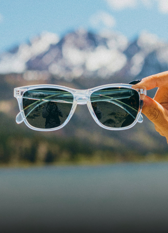 Sunglasses held in front of a mountainous landscape