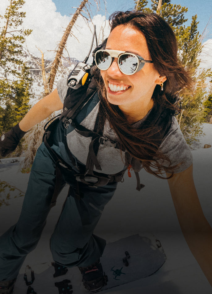 Person snowboarding in a snowy landscape with trees