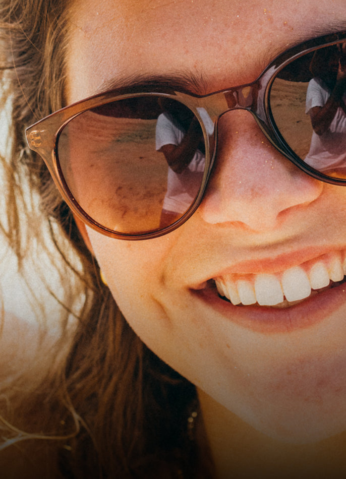 Close-up of a person wearing sunglasses with a blurred background