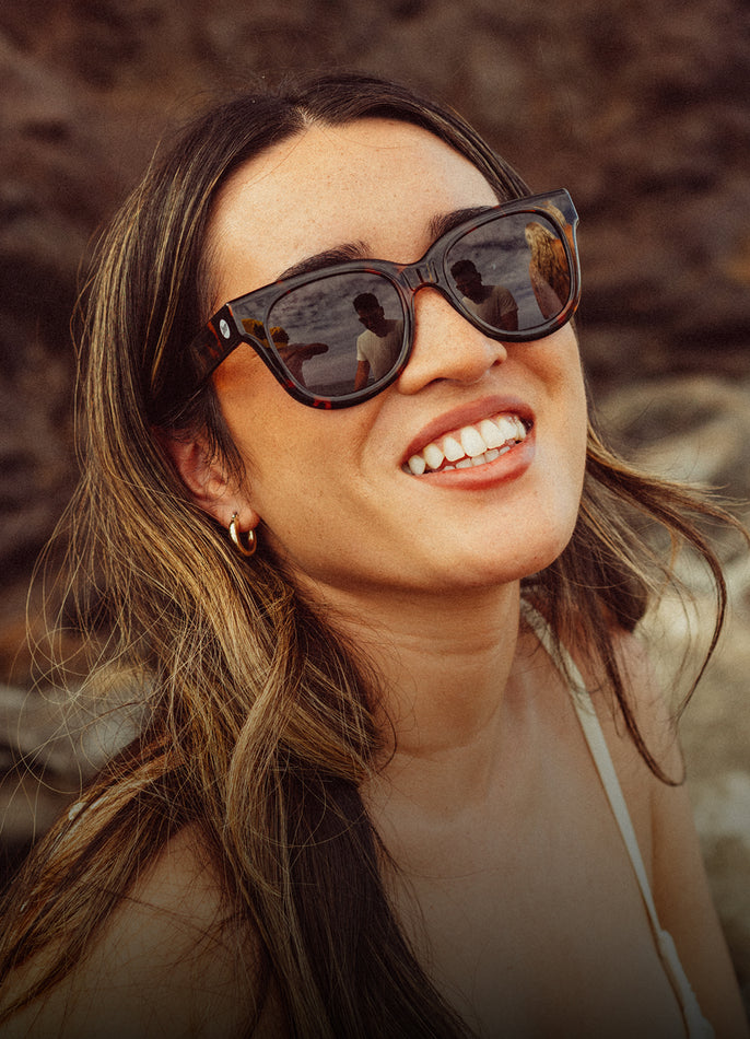 Woman wearing sunglasses with a blurred natural background