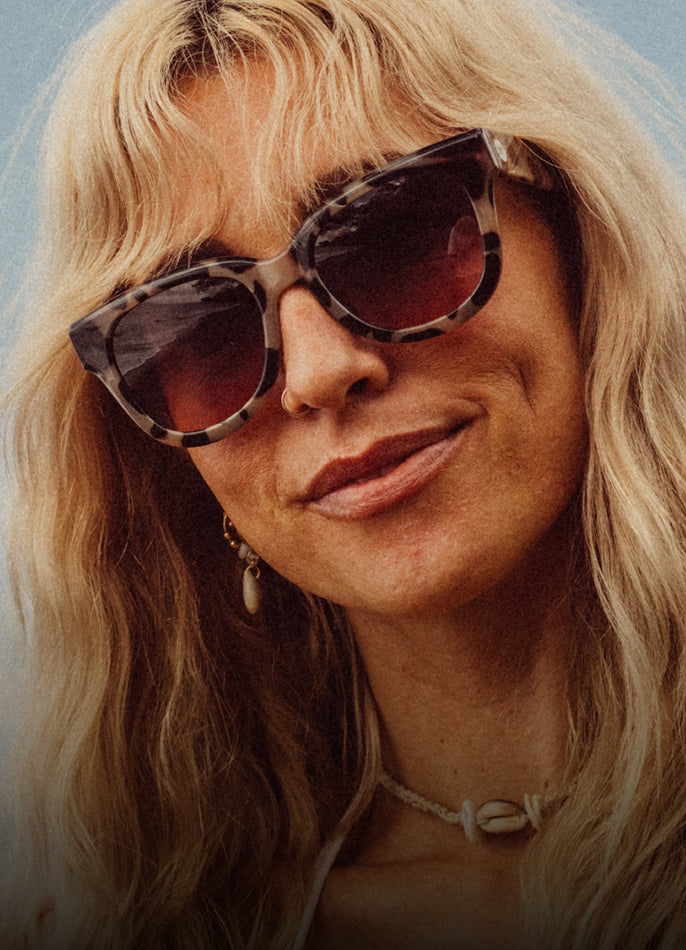 Close-up of a person wearing sunglasses with a blurred background