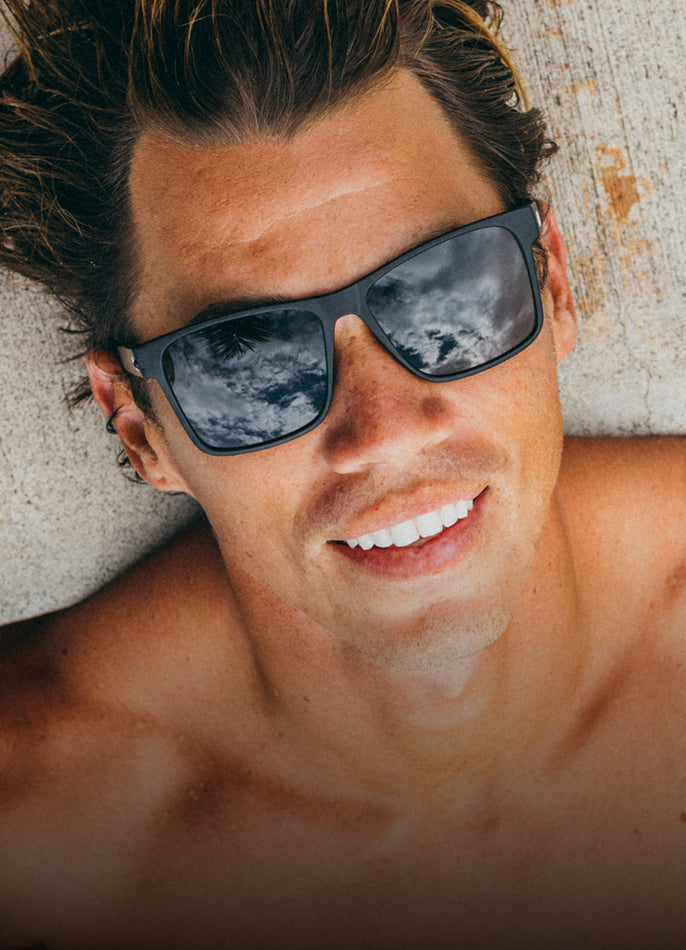 Man wearing sunglasses with a neutral background