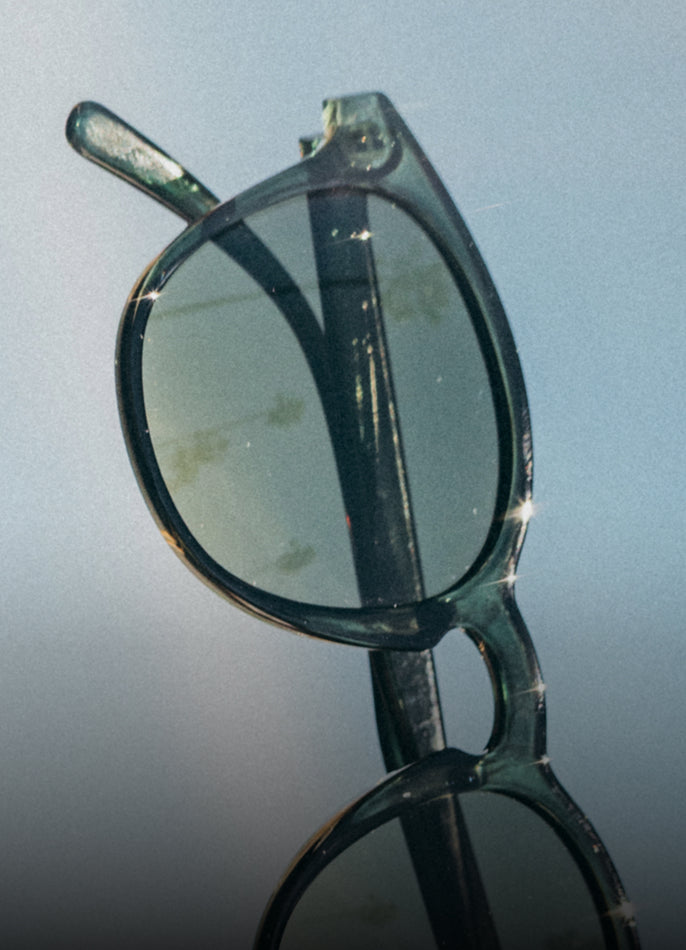 Pair of eyeglasses with a reflective surface on a blue background
