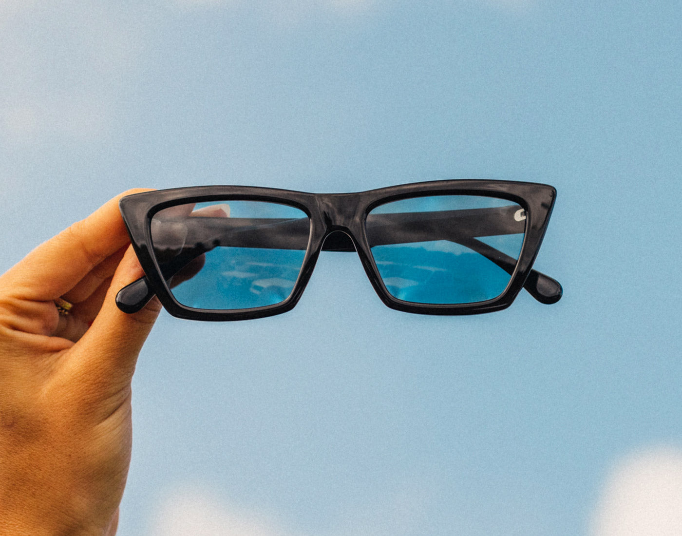 hand holding sunski fiorella black slate sunglasses